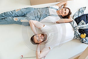 Two happy lovers lying on floor and looking up