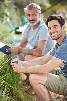 two happy male friends fishing in morning