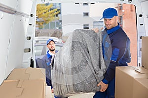 Two Movers Unloading Furniture From Truck photo