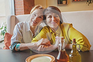 Two happy mature women in restaurant