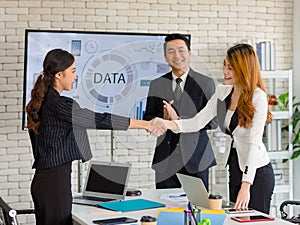 Two happy millennial professional successful businesswomen in formal suit standing shaking hands greeting together when business