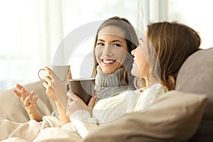 Two roommates talking on couch in winter photo