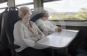 Two happy senior woman on a train