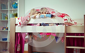 Two happy sibling children having fun in bunk bed