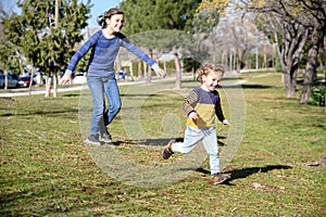Two happy siblings having fun while running in springtime