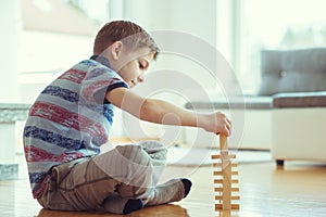 Two happy siblings playing a game with wooden blocks at home