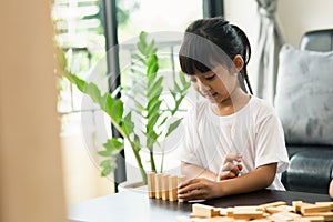 Two happy siblings playing a game with wooden blocks at home joyfully