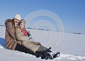 Two happy sisters sledding
