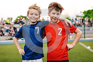 Two Happy Smiling Boys in Sports Team Standing on Grass Pitch