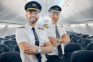 Two happy smiling men in uniform keeping arms crossed