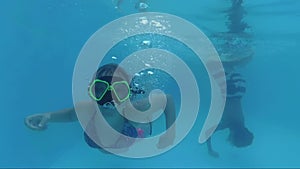 Two Happy Smiling Underwater Girls And Boy Swim In Swimming Pool