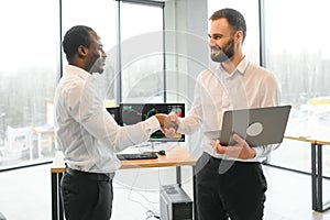 Two happy successful excited diverse traders investors giving high five celebrating successful stock exchange trading