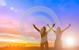 Two happy successful women raising arms toward beautiful scenery. People achieve life target goal. Business women raises hands as