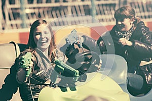 Two happy teen girls driving a bumper cars