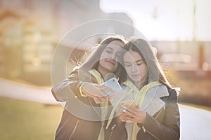 Two happy teenage girls friends using on mobile phone