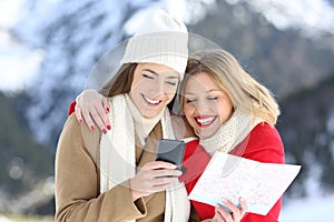 Two happy tourists searching on line in winter holidays