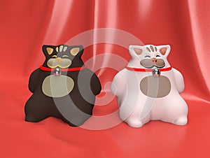 Two happy toy cats. One white, one black, sitting over a red background