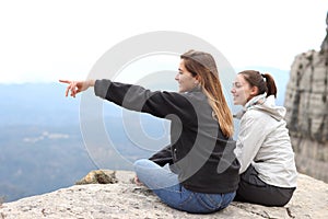 Two happy trekkers sitting contemplating views outdoors