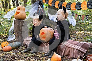 two happy twins boys kids in halloween costumes having fun in halloween decorations outdoor