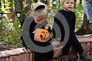 two happy twins boys kids in halloween costumes having fun in halloween decorations outdoor