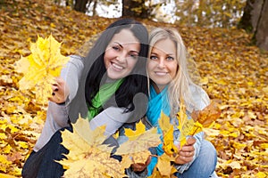 Two happy women in autumn forest