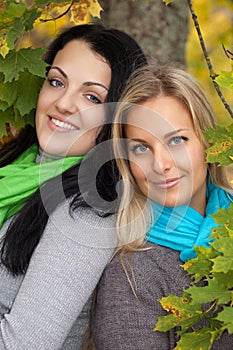 Two happy women in autumn forest