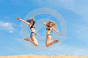 Two happy women jumping high with fun