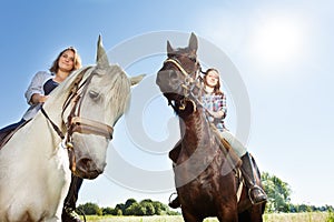 Two happy women riding beautiful purebred horses