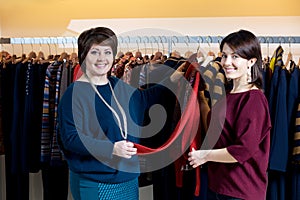 Two happy women shopping in clothes store