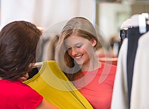 Two happy women shopping in clothes store