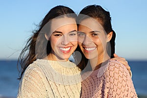 Two happy women smiling with perfect smiles at camera