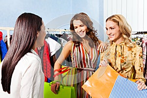 Two happy women talking with shop assistant