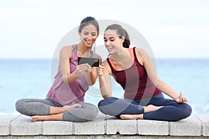 Two happy yogis watching online yoga class