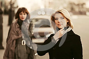 Two happy young fashion women on a city street