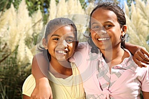 Two happy young school girls in friendship hug