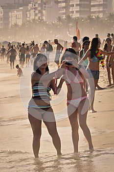 Two happy young women enjoy Carnival in Ipanema beach