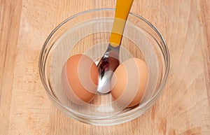Two hard-boiled eggs in a glass bowl