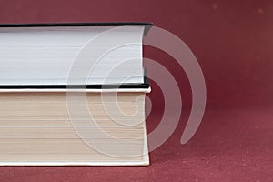 Two hardcover books stacked together on red background.