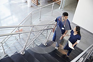 Two healthcare colleagues talking on the stairs at hospital