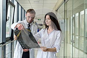 Two healthcare professionals looking at x-ray image,  mri brain  of patient for diagnosis