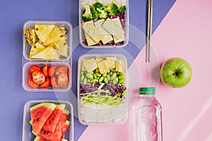 Two healthy asian-style plant-based lunch boxes knolled together on blue and pink background