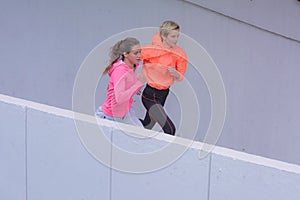 Two Healthy young female sporty women running in morning on street. Runner training outdoors in morning