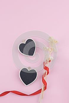 Two heart shape board decorate with white dried flowers bouquet