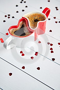 Two heart shaped coffee cups conected with each other.