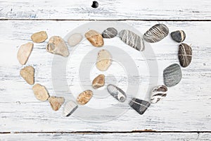 Two heart shaped pebble stones on a old wood