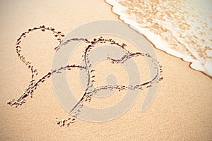 Two heart shapes inscribe on sand photo