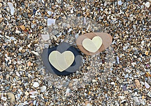 Two Hearts on Black and Red Rocks on Sand