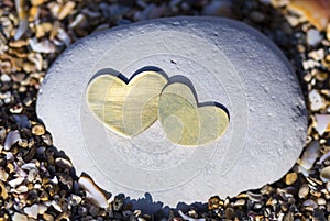 Two Hearts on a Bright Rock on Sand