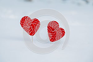 Two hearts-candy in the snow. the concept of Declaration of love and sweets, Valentine`s Day. A sweet symbol of love