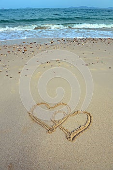 Two hearts drawn in sand